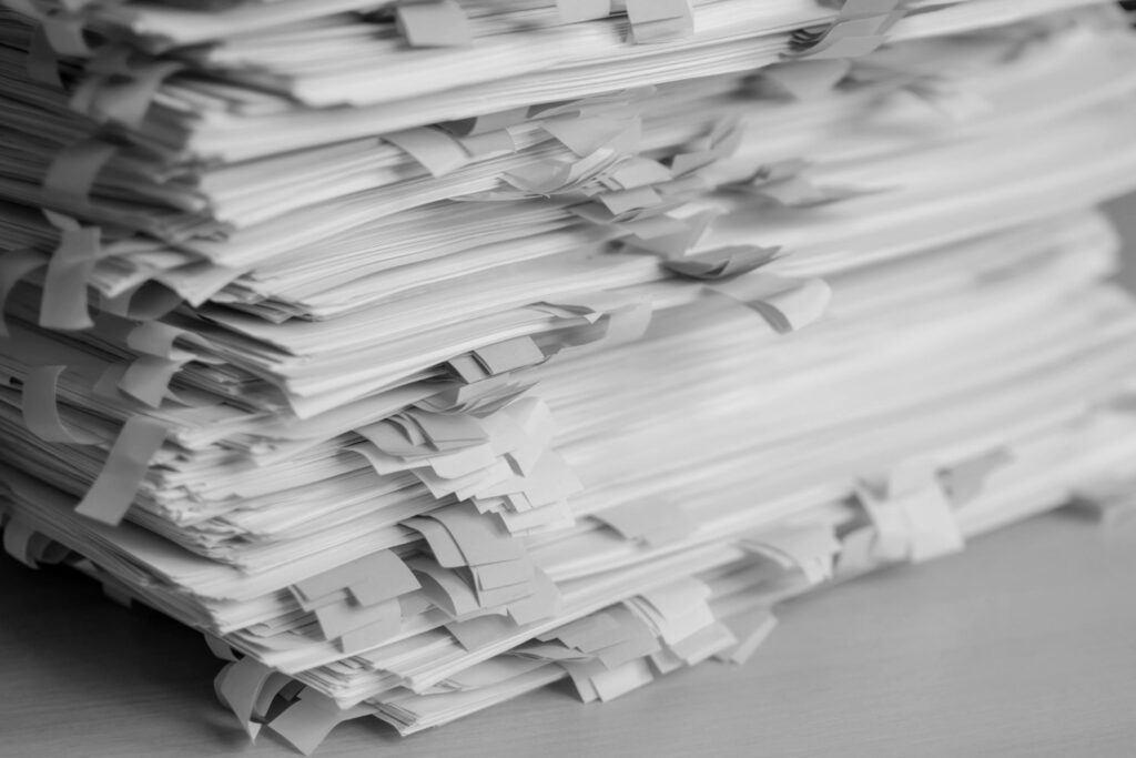 Pilha de documentos organizados com marcadores coloridos