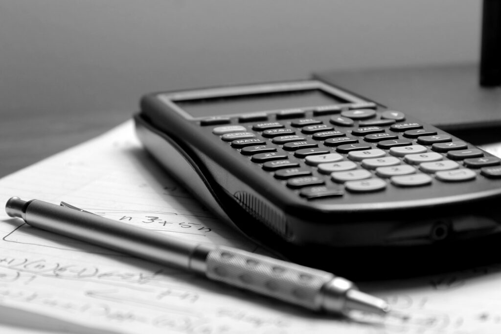 Calculadora e caneta sobre planilha impressa